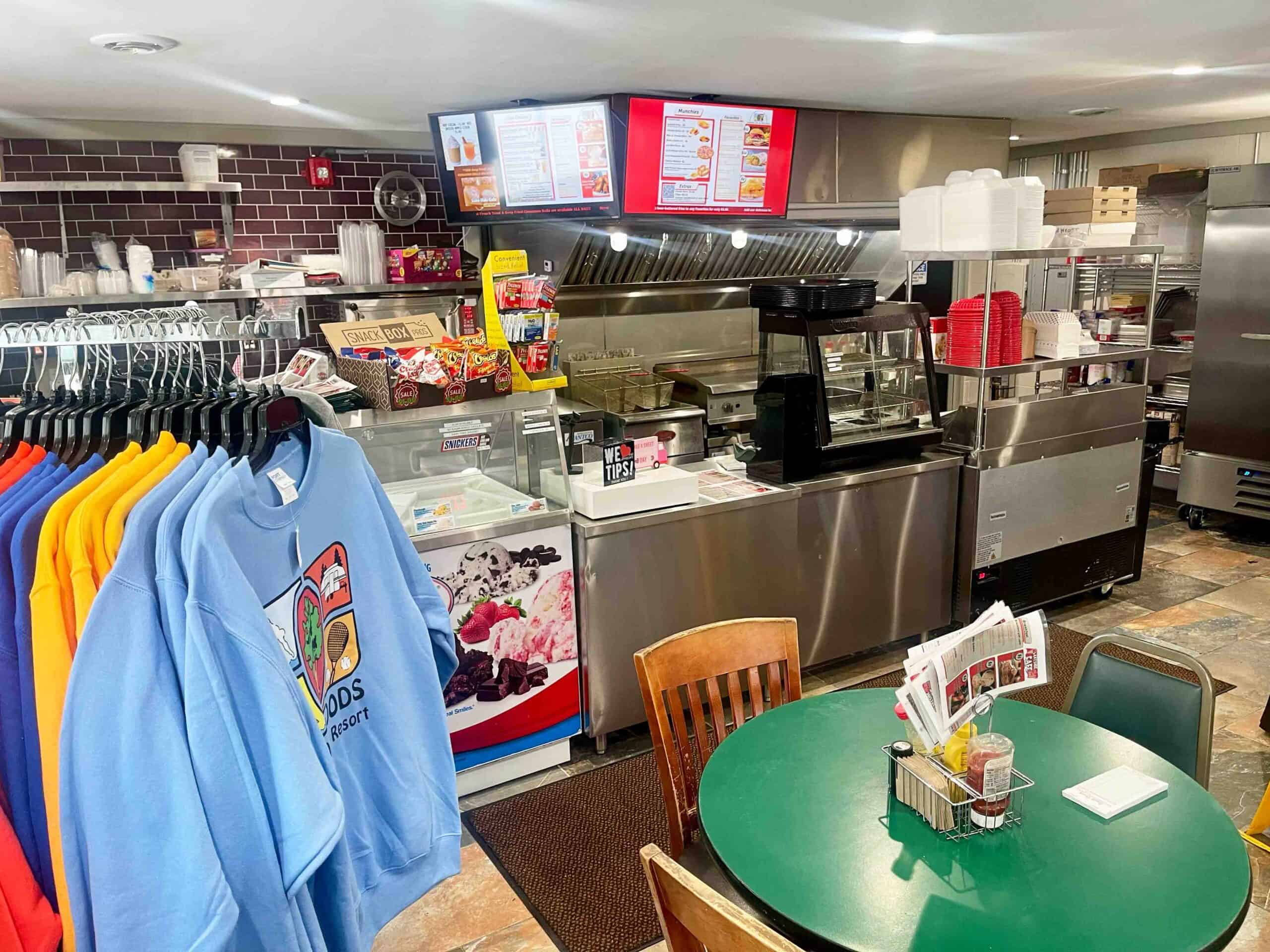 Indoor dining and snack options at Waldenwoods Family Recreation Resort, with vibrant apparel on display.
